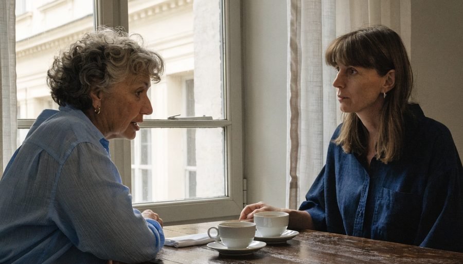 Duas mulheres em conversa junto a uma janela