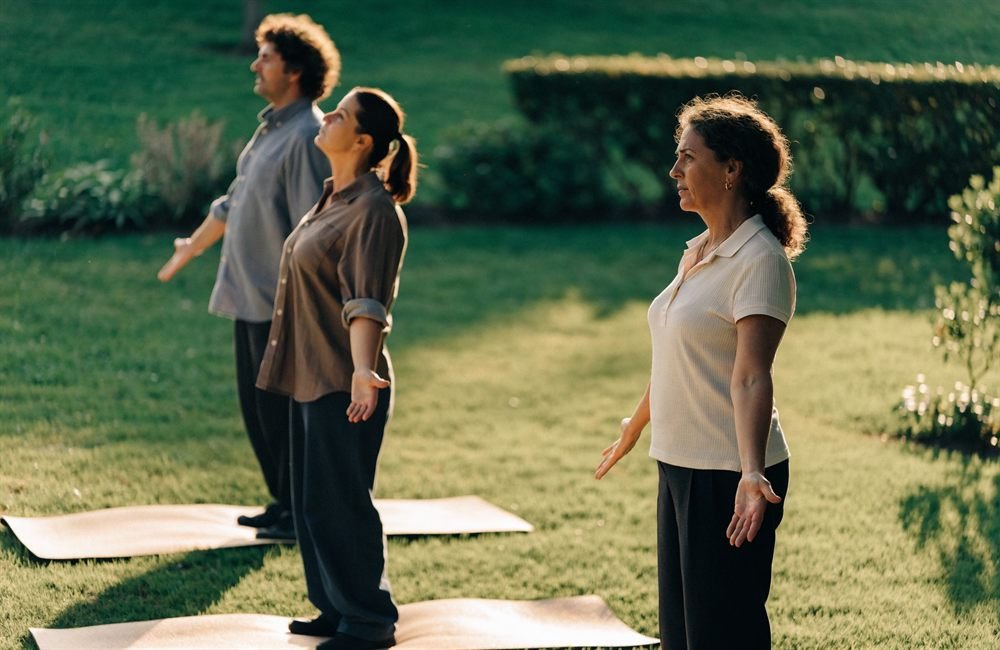 Fisioterapeuta a orientar um exercício postural no relvado, ao ar livre