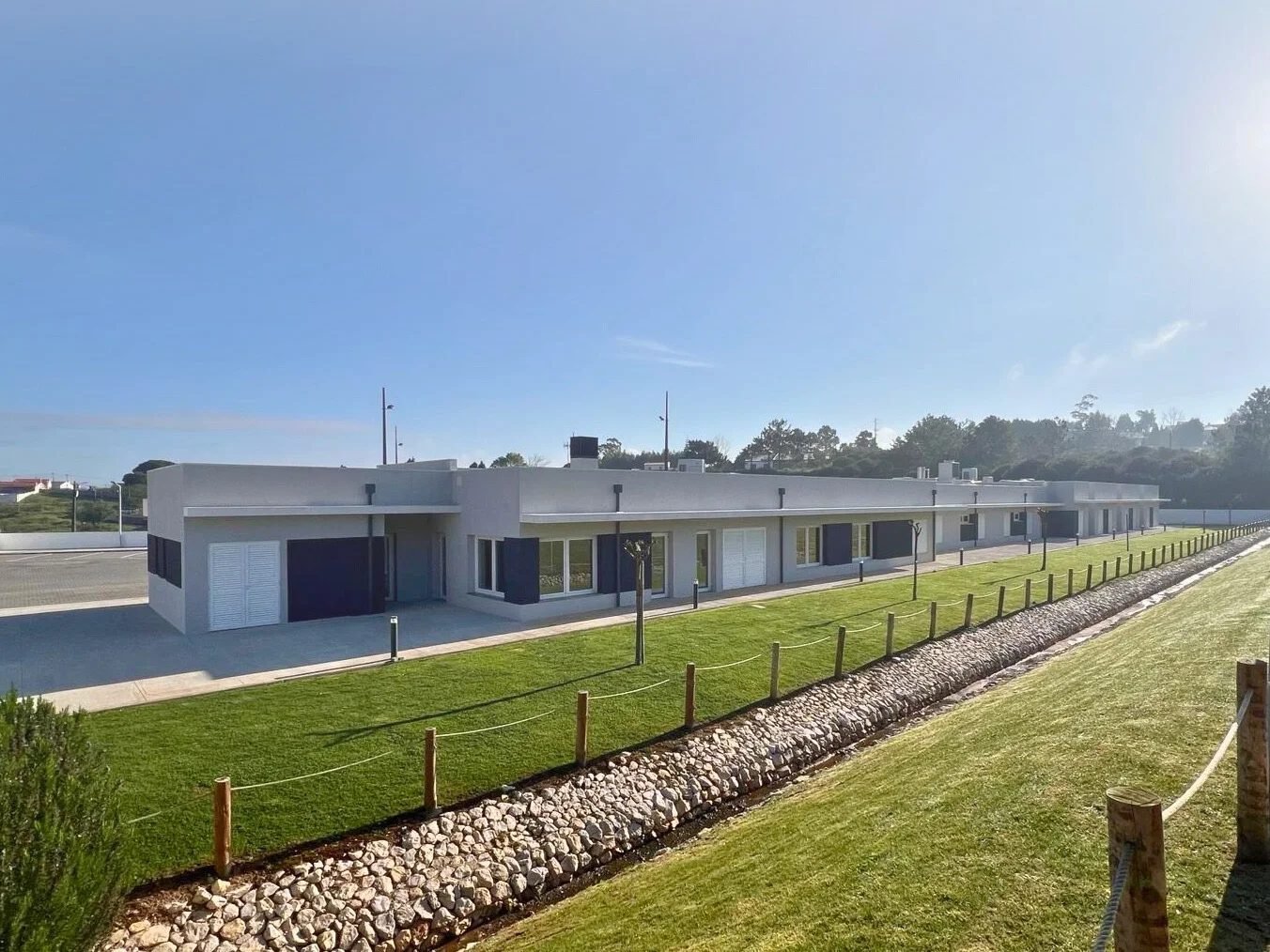 A sede da Vida Maior Oeste, no Ameal: edifício baixo e branco com portadas azul-escuras e relvado em frente